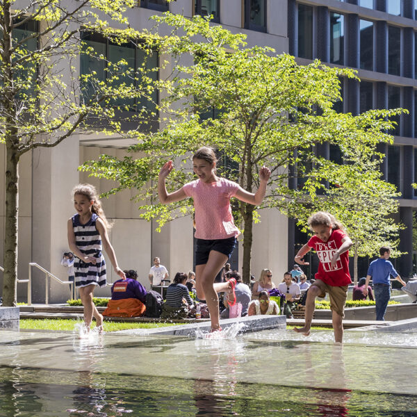 Pancras Square, three girls run through the water feature at King's Cross